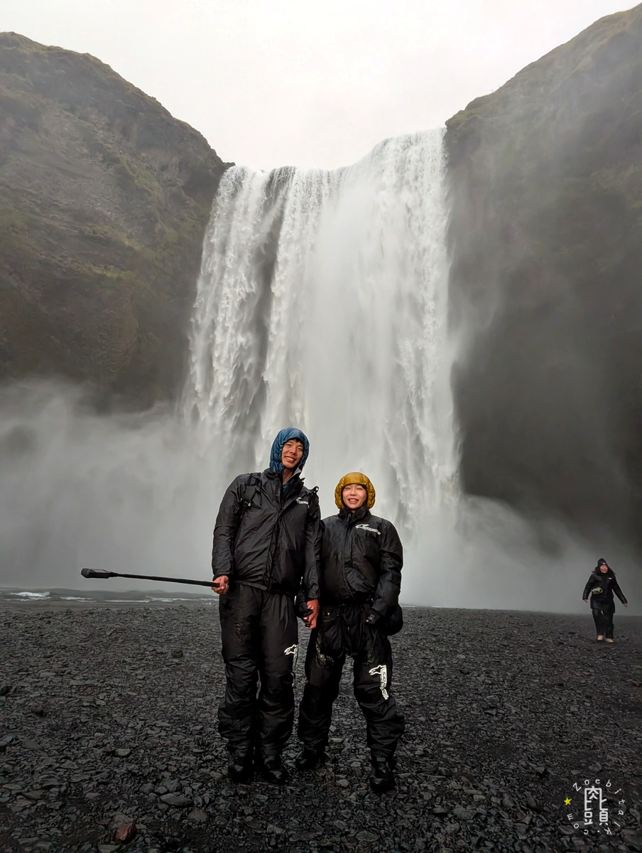 Skógafoss 瀑布前的兩位旅行者與冰島強風水霧