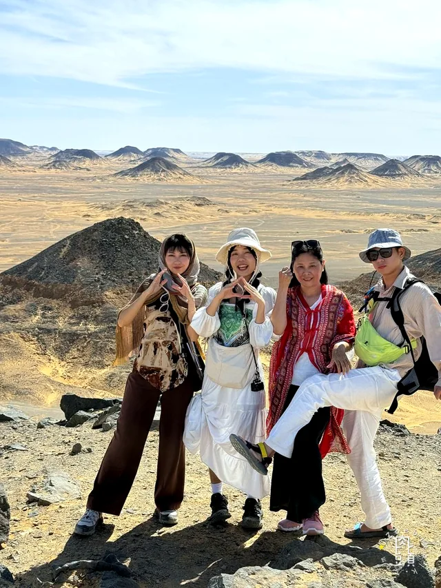 全家終於在高處集合,背後是一路延伸到遠方的黑色山丘
