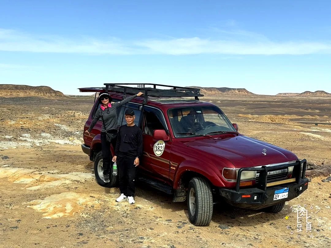 越野車停在寬闊地景中,人與車都成了辨認尺度的參照