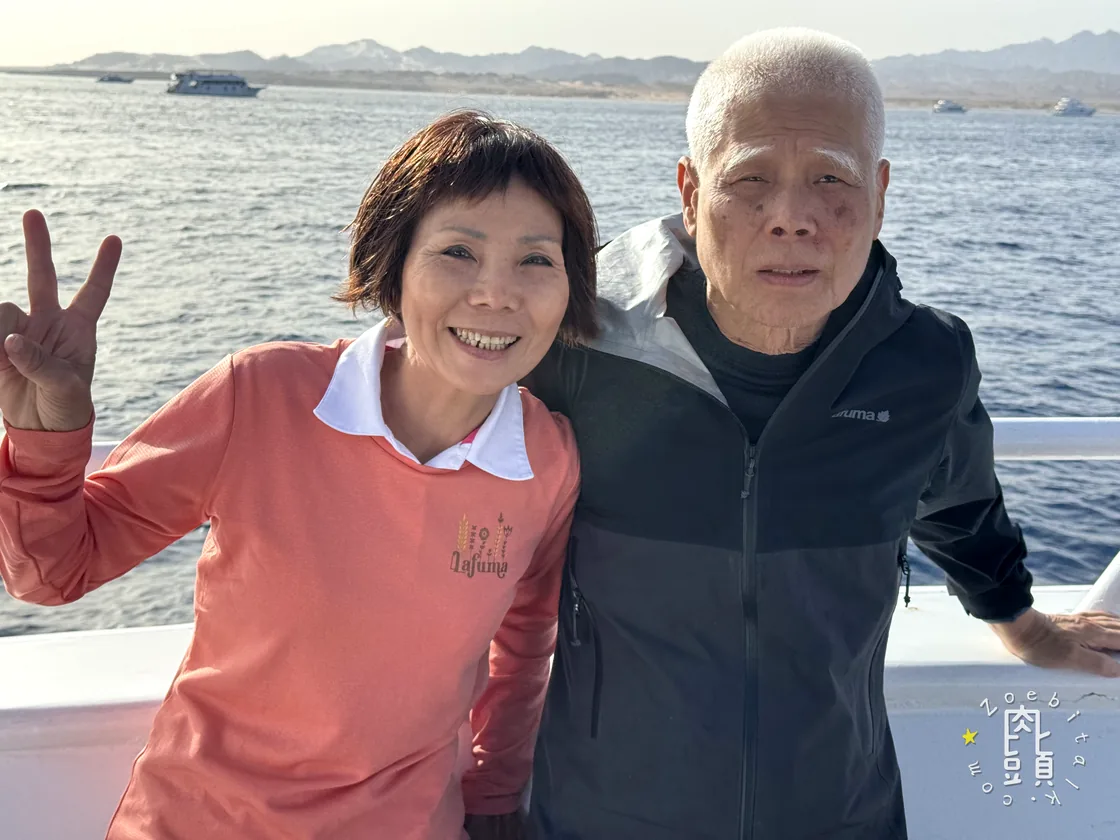 爸媽在船頭一起比出手勢,紅海與西奈山稜完整留在身後