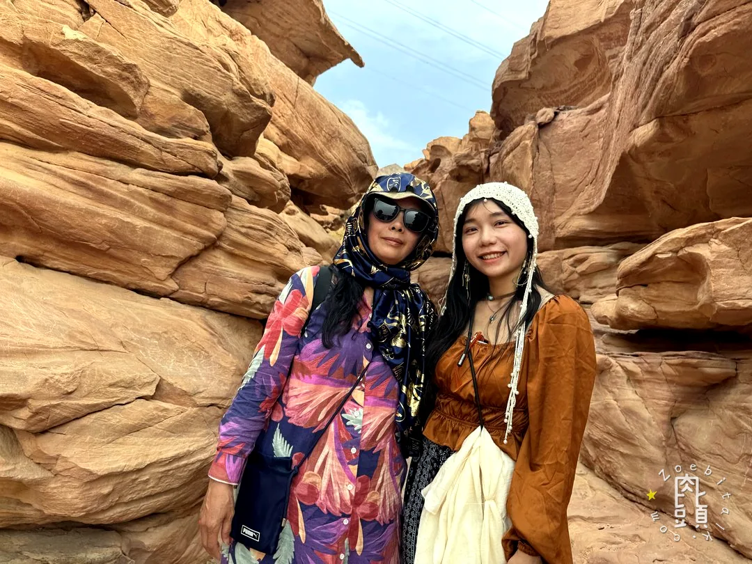 媽媽在層層岩石間停下來，身後仍有人繼續往內走